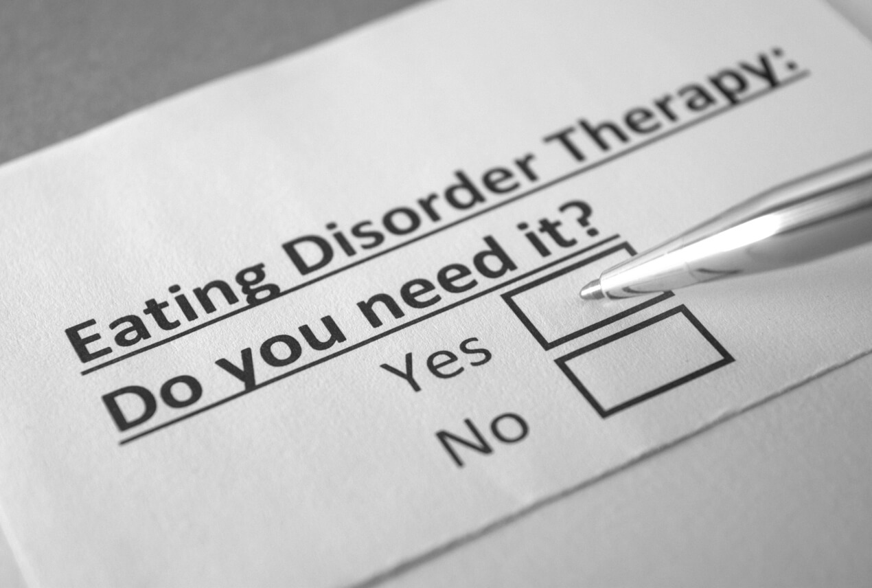 A pen is marking a box on a questionnaire about eating disorder therapy.