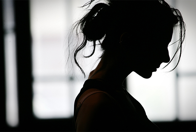 silhouette of woman with messy hair bun on gray background