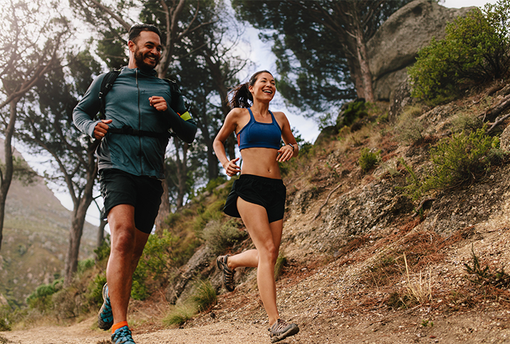 A-man-and-a-woman-running-on-an-outdoor-mountain-trail