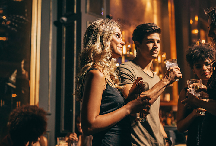 A group of people stand together drinking alcohol.