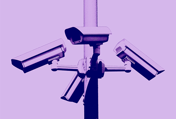 Four security cameras face different directions with a purple filter over the photo.