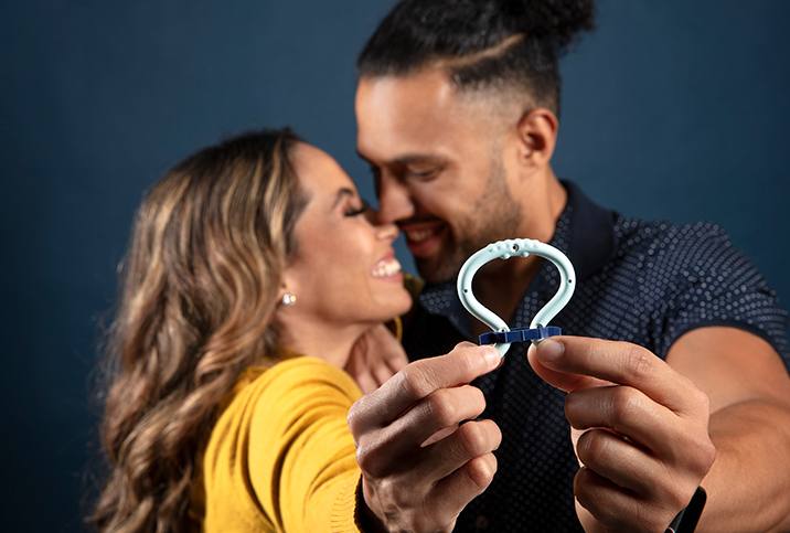 A man and woman touch faces, smiling, and hold an Eddie device toward the camera.