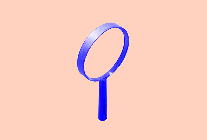 A blue magnifying glass is on a pink background.