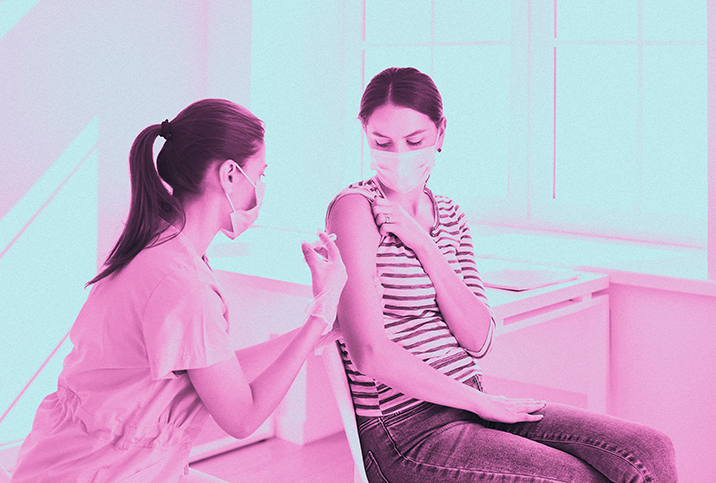 A nurse gives a woman a vaccine for COVID-19.