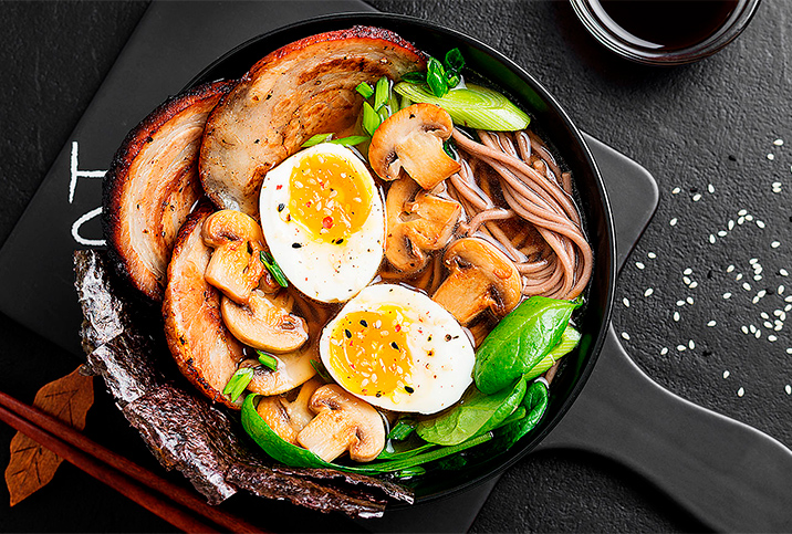 A pan with eggs and vegetables sits on a black counter.